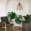 A hanging lamp is shown above a chair and a large potted plant in a room with an arched wall. Náhled obrázku produktu