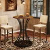 A round bar table with two stools in a room with a brick wall and a window. Produktbild-Vorschau