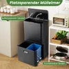 A multi-compartment trash can with its lid open, showing the interior bins, placed in a kitchen setting next to a cabinet and a shelf with kitchen appliances and vegetables. Podgląd zdjęcia produktu