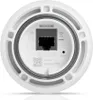 The bottom of a white cylindrical electronic device, showing a port and some text and symbols. Produktbild-Vorschau