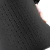A hand is holding and bending a piece of black foam padding with pre-cut slots. Produktbild-Vorschau