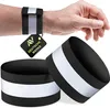 A person's wrist wearing a black reflective band, with two more bands in the foreground. Náhľad obrázku produktu