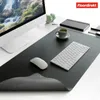 A desk setup with a computer monitor, keyboard, mouse, headphones, and a cup of coffee on a large desk mat. Anteprima dell’immagine prodotto