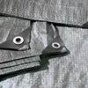 Close-up of a gray tarp with reinforced corners and grommets. Náhled obrázku produktu