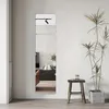A modern living room with a plant and a stool next to a set of mirrors. Anteprima dell’immagine prodotto