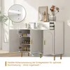 A modern white sideboard with gold accents, featuring open doors revealing shoe storage and a drawer. The image includes a close-up detail of shelf support and decorative flowers in the background. Náhled obrázku produktu