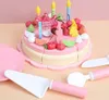 A toy birthday cake with candles and fruit decorations, along with cake serving utensils. Anteprima dell’immagine prodotto