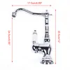 A chrome-finished kitchen faucet with white ceramic handles, shown against a white background with measurement indicators. Produktbild-Vorschau