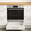 A built-in oven with an open warming drawer, set against a kitchen counter and cabinets. Náhľad obrázku produktu