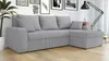 A gray sectional sofa with a chaise lounge is shown in a living room setting, with artwork on the wall and a floor lamp. Náhľad obrázku produktu