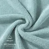 A close-up, swirled view of a light blue towel, showing its texture and some text overlays. Produktbild-Vorschau