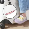 A child's foot wearing a purple and yellow shoe is placed on the side of a white rolling suitcase designed to look like a panda. Produktbild-Vorschau