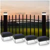Four solar-powered fence post lights are displayed in front of a black fence at dusk. Produktbild-Vorschau