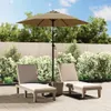 Two lounge chairs and a patio umbrella are set up on a paved patio area, with lush green bushes and a wooden fence in the background. Náhled obrázku produktu