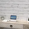 A white portable DVD player sits on a wooden desk next to a book and an alarm clock. Náhľad obrázku produktu