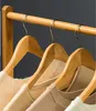 Close-up of wooden hangers with clothes on a rack. Produktbild-Vorschau