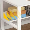 A white computer desk with shelves holding boxes and books. Yellow arrows and dashed lines highlight storage areas. Produktbild-Vorschau