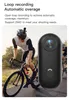 A cyclist wearing a helmet rides a bicycle, with a small black action camera in the foreground. Náhled obrázku produktu