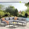 An outdoor lounge set with a sectional sofa, armchair, and coffee table is set up on a patio next to a swimming pool, with lush greenery and a building in the background. Produktbild-Vorschau