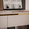 A close-up view of a modern desk with a laptop on it and drawers below. Produktbild-Vorschau
