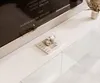 A lowboard with a TV screen and decorative items on top. Produktbild-Vorschau