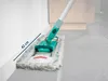 A mop head with a teal handle is shown cleaning along a white baseboard on a gray tiled floor. A blue arrow indicates a measurement of 42 cm. Produktbild-Vorschau