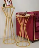 Two gold accent tables are shown next to a red velvet sofa. One table has a framed picture on it, and the other has a decorative bowl with some items in it. Produktbild-Vorschau