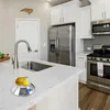 A digital kitchen scale with fruit on it, placed on a kitchen counter next to a sink. Produktbild-Vorschau