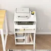 A white multifunctional modern standing cabinet with a printer on top, next to a desk. Produktbild-Vorschau