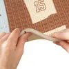 Hands are shown bending a corner of a play mat with a textured pattern and the number 15 printed on it. Produktbild-Vorschau