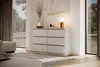 A modern bedroom or living room setting with a dresser, ottoman, rug, and large window. Produktbild-Vorschau