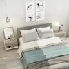 A bedroom scene with a bed, nightstands, and artwork. Produktbild-Vorschau