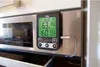 A digital thermometer attached to the front of a stainless steel oven. Produktbild-Vorschau