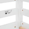 A close-up view of a white wooden bed frame, showing a label with product information and safety symbols. Produktbild-Vorschau