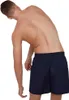 A person is shown from the back, bending to the side, wearing blue swim shorts. Produktbild-Vorschau