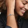 A woman's arm with a Pandora bracelet and a heart-shaped charm. Anteprima dell’immagine prodotto