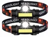 Two black LED headlamps with orange accents and patterned headbands are shown against a white background. Anteprima dell’immagine prodotto