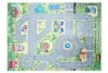 A top-down view of a colorful children's play mat depicting a town with roads, buildings, a park, and a train track. Produktbild-Vorschau