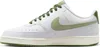 A side view of a white Nike Court Vision Low sneaker with green accents. Produktbild-Vorschau