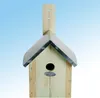 A wooden birdhouse with a metal roof against a light blue background. Produktbild-Vorschau