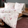 A neatly made bed with floral patterned bedding. Produktbild-Vorschau