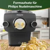 A Philips pasta maker attachment with pasta being extruded, displayed on a wooden surface with a pile of finished pasta in the foreground. Náhled obrázku produktu