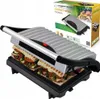 A contact grill with sandwiches inside, shown with its packaging in the background. Voir les images du produit