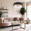A luxurious living room with a pink curved sofa, a marble coffee table, and a large plant. Produktbild-Vorschau