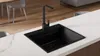 A black kitchen sink and faucet are shown on a white countertop. Produktbild-Vorschau
