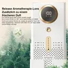 A white electronic device with gold accents is shown against a blurred background of green pine trees and bokeh lights. Text overlays describe its aromatherapy and air freshening features. Produktbild-Vorschau