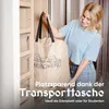 A woman is holding a large fabric bag with a logo and text on it, standing in front of a closet. Produktbild-Vorschau
