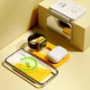 A collection of electronic accessories, including a wireless charger, smartwatch, and earbuds, arranged on a yellow and light gray surface. Voir les images du produit