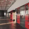 A hallway with lockers and overhead pipes. Voir les images du produit