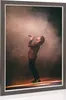 A man singing on stage with smoke and spotlights. Produktbild-Vorschau